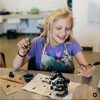 child painting a sculpture